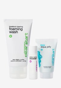 Trois produits de soin de la peau : un tube blanc de nettoyant moussant avec des accents verts, un tube roulant blanc pour le booster, et un tube en gel aqua bleu clair.
