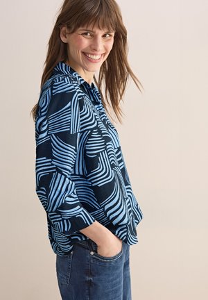 Blouse à motifs en tissu bleu foncé avec des rayures abstraites bleu clair, design avec col, coupe décontractée et manches trois-quarts.
