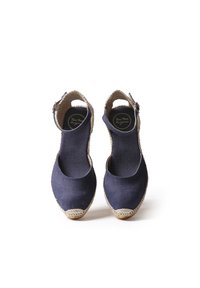Espadrilles in tela blu navy con punta rotonda, cinturino alla caviglia e dettagli in juta intrecciata attorno alla suola. Texture liscia in tutto il prodotto.