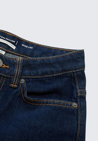 Jeans a gamba larga di colore blu scuro, realizzati in materiale riciclato, con cuciture arancioni a contrasto e un bottone in metallo. Include tasche frontali.