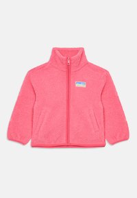 Veste en polaire de couleur rose vif avec un col montant, fermeture éclair à l'avant et une surface douce et texturée. Elle possède des poches latérales et un écusson avec un logo.