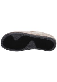 Wollslippersohle mit einem hellbeigen Außenmaterial und einer dunkelgrauen Filzunterseite, ausgestattet mit einer ausgeprägten, konturierten schwarzen Gummieinlage für besseren Halt.
