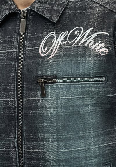 Σκούρο καρό μπουφάν με φερμουάρ μπροστά και τσέπη στο στήθος με φερμουάρ, με λογότυπο "Off-White" σε λευκά καλλιγραφικά γράμματα στο αριστερό στήθος.