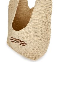 Beige színű, kerek alakú, szőtt táska. Természetes rostokból készült, texturált felülettel. Kis barna díszítő elemmel rendelkezik.