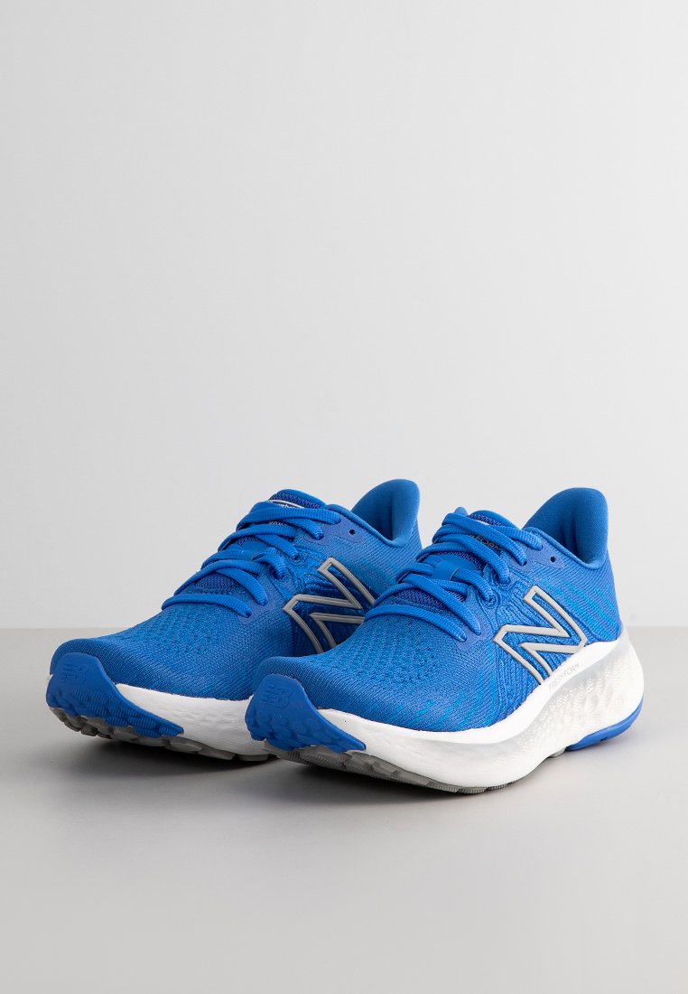 Blaue Sportschuhe aus Mesh-Stoff mit einer strukturierten Oberfläche, ausgestattet mit einer weißen gepolsterten Sohle und grauen Akzenten auf dem Logo und den Ösen.