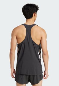 Débardeur sportif noir avec une texture perforée, design dos nageur, avec des rayures blanches et grises sur les côtés.