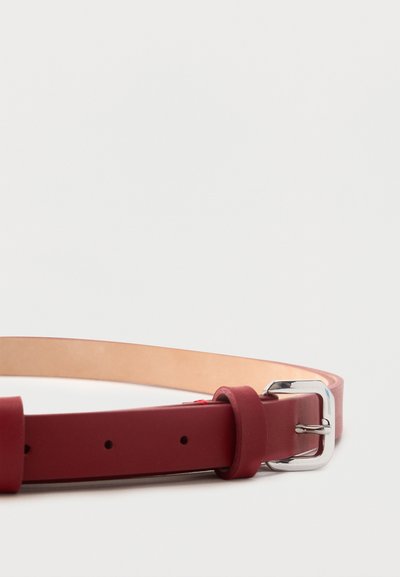 Κόκκινη δερμάτινη ζώνη με ασημένια μεταλλική αγκράφα, τοποθετημένη επίπεδη σε απλό λευκό φόντο.