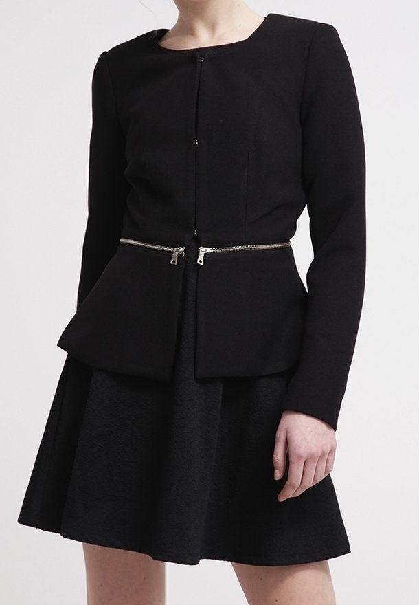 Schwarze Peplum-Jacke mit langen Ärmeln und rundem Ausschnitt, mit einem silbernen Reißverschluss-Akzent. Der Rock ist ausgestellt und aus strukturiertem Stoff.