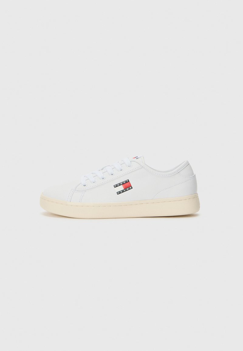 Vita sneakers i slät läder med en beige gummisula. Har en liten mångfärgad logotyp på sidan och traditionell snörning.