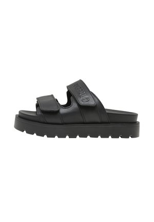 Sandalias tipo slide de cuero negro con correas ajustables de velcro, superficie texturizada, diseño de punta abierta y una suela gruesa de goma con detalles acanalados.