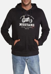 Sudadera de algodón negra con bolsillos tipo canguro en el frente, capucha con cordón y estampado gráfico blanco que presenta una motocicleta y el texto "MUSTANG" en el pecho.