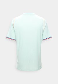 Ανοιχτό μπλε αθλητική μπλούζα με κοντά μανίκια, πορτοκαλί ραφές στους ώμους και μανσέτες με ρίγες κόκκινου, λευκού και μπλε χρώματος, εμφανίζεται από πίσω.