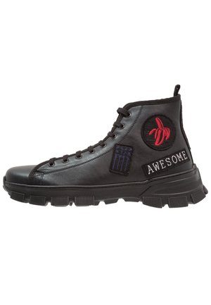 Czarny wysoki sneaker z grubą podeszwą, czerwona naszywka z wyhaftowanym bananem, niebieska prostokątna naszywka oraz naszywka z napisem "AWESOME" po boku.