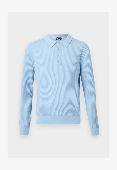 Polo à manches longues côtelé bleu clair avec patte de boutonnage et petite étiquette en métal de la marque sur le côté avant inférieur.