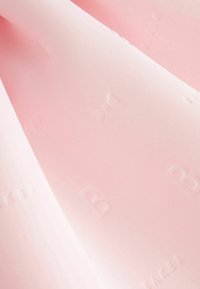 Jasnoróżowa tkanina o gładkiej fakturze z wytłoczonym logo i wzorem na całej powierzchni, tworząca subtelne różnice w detalu powierzchni.