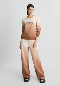 Bruine en beige gradient lounge set met een sweatshirt met ronde hals en logo, gecombineerd met bijpassende wijde broek. Gladde stof met een ontspannen pasvorm.