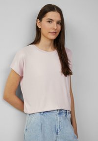 Lichtroze, kortmouwen top met een ronde hals en een zachte, glanzende textuur. Draag het met hoog-waist lichtblauwe spijkerbroek.
