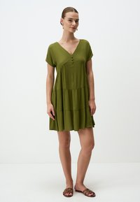 Olivengrünes Kleid mit V-Ausschnitt, kurzen Ärmeln und gestuftem Design. Verfügt über drei Knöpfe auf der Vorderseite und besteht aus einem weichen, strukturierten Stoff.