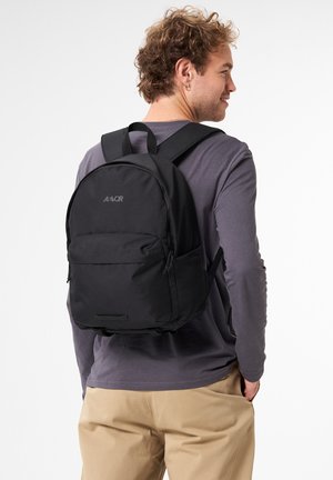 Schwarzer Rucksack mit einer glatten, matten Oberfläche, ausgestattet mit einer Front-Reißverschlusstasche, verstellbaren Trägern und einem schlichten Logo oben.
