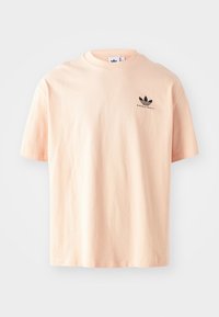 T-shirt de algodão rosa pálido com decote redondo e mangas curtas. Apresenta um pequeno logotipo preto da Adidas Basketball no peito.