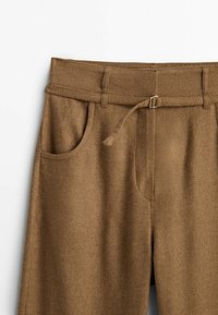 Pantalon marron taille haute avec poches latérales et ceinture en tissu avec une petite boucle métallique à la taille.