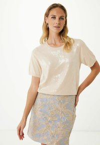 Haut en sequins crème à manches courtes, associé à une jupe bleue ornée de broderies florales dorées. Texture lisse et design ajusté.