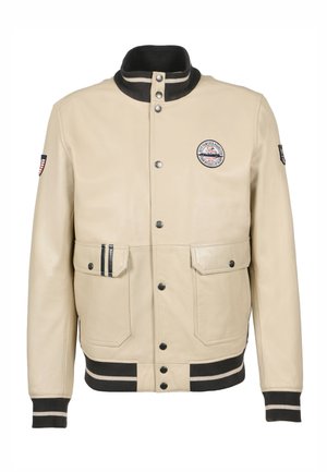 Veste en cuir beige avec un col côtelé noir, deux poches avant, un patch logo sur la poitrine, et des poignets et un ourlet rayés noirs contrastants.