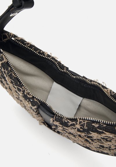Svart bag med teksturert vevd overflate, frynsete detaljer og en glatt svart glidelås. Innvendig foret med lysegråt stoff.