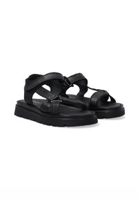 Schwarze Leder-Sandalen mit überkreuzten Riemen, verstellbarem Schnallenverschluss und strukturierten Sohlen. Sie verfügen über ein geformtes Fußbett und einen stabilen Blockabsatz für zusätzlichen Halt.