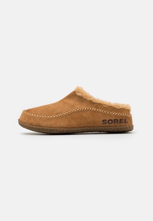 Brown suede slip-on slipper with faux fur lining and stitching details. Features textured rubber sole and "SOREL" logo on the side.