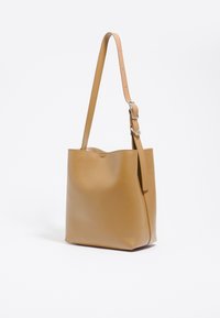 Borsa a tracolla in pelle tan con una texture liscia, spallaccio singolo e design a apertura superiore. Forma semplice e rettangolare senza decorazioni.