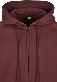 Bordeaux huppari vetoketjulla, joka on valmistettu pehmeästä kankaasta ja jossa on etuvetoketju, nauhat sekä etiketti, jossa lukee "URBAN CLASSICS."