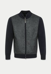 Herren-Jacke mit Reißverschluss, ausgestattet mit einem strukturierten grauen und schwarzen Karomuster sowie einfarbigen marineblauen Ärmeln, Kragen und Rippbündchen.