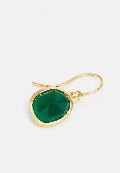Cercei cu piatră verde tăiată în fațete, cu c�ârlig din metal de culoare aurie. Piatra are o formă neregulată, octagonală și o textură netedă, lustruită.
