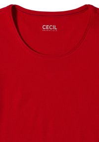 T-shirt rouge à col rond montrant l’étiquette "CECIL ESSENTIALS" imprimée à l’intérieur du col.