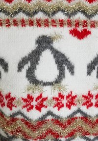 Strickmönster med grå pingviner, röda snöflingor och gyllene garn accenter på en vit bakgrund.