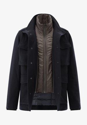 Navy outer coat with multiple pockets, button closures, and a stand collar; features a removable brown quilted inner layer with a zip.