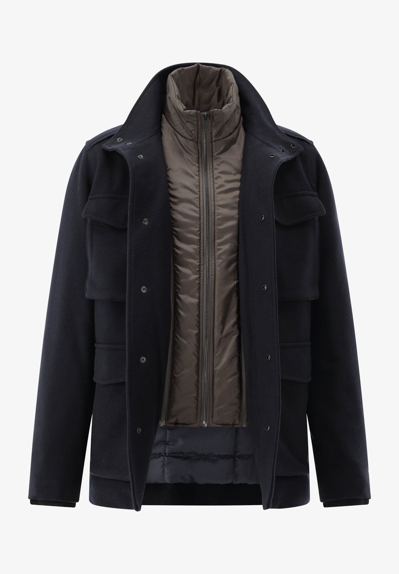 Navy outer coat with multiple pockets, button closures, and a stand collar; features a removable brown quilted inner layer with a zip.