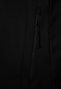 Czarna tkanina o gładkiej fakturze z detalem w postaci kieszeni zapinanej na zamek błyskawiczny. Zamek ma czarną uchwyt. Ogólnie rzecz biorąc, prosta i funkcjonalna konstrukcja.