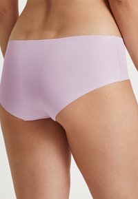 Lavanda bezšavne gaćice s glatkim, rastezljivim materijalom i jednostavnim dizajnom, bez vidljivih šavova ili ukrasa.