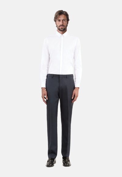 Witte overhemd met knopen, donkergrijze slim-fit broek, elegante zwarte schoenen. Minimalistisch ontwerp met een moderne pasvorm en gladde stoftexturen.