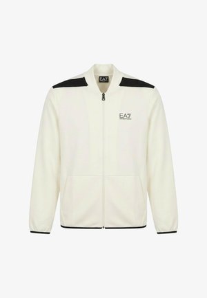 Giacca bianca con zip, strisce nere sulle spalle, polsini elasticizzati, tasche frontali e logo EA7 Emporio Armani sul petto.