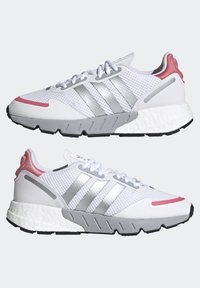 Vita träningsskor i vitt med ovandel i mesh, silverfärgade tre ränder, rosa detaljer på tån och hälen, texturerad sula samt en distinkt dämpad mellansula.