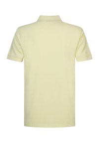 Polo shirt à manches courtes jaune pâle, avec un col côtelé et un ourlet droit, en tissu de coton doux avec une texture lisse.