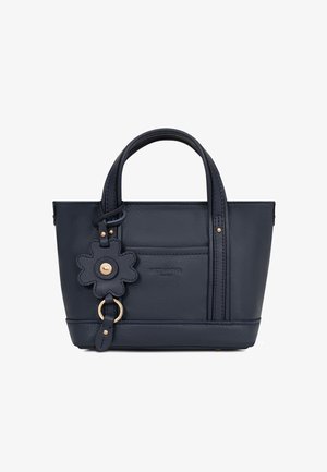 Petit sac à main en cuir bleu marine avec double poignées, poche avant, et un accessoire porte-clés en forme de fleur avec des ferrures dorées.