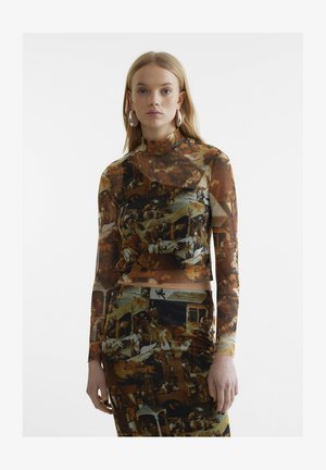 Μακρυμάνικο, διαφανές μπλουζάκι με πολύχρωμο σχέδιο που απεικονίζει ιστορικές σκηνές. Η εφαρμοστή γραμμή και το ψηλό λαιμόκομμα συμπληρώνουν το στιλ.