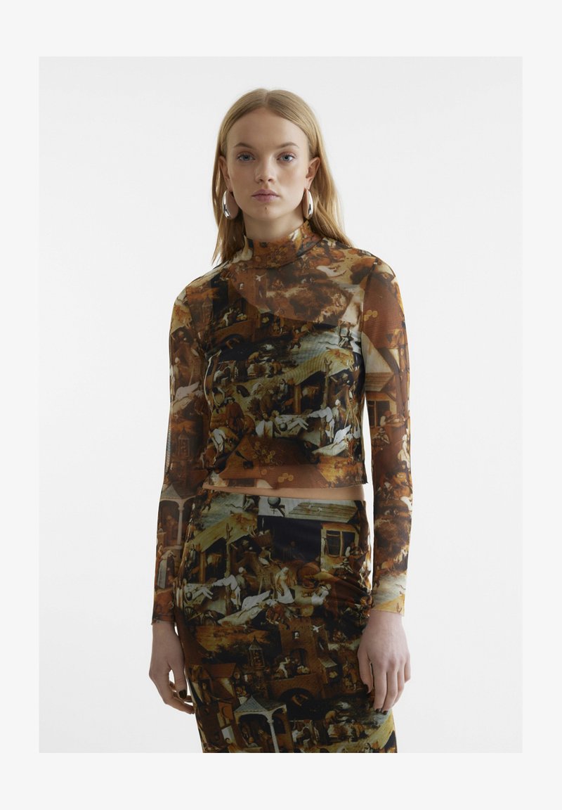 Μακρυμάνικο, διαφανές μπλουζάκι με πολύχρωμο σχέδιο που απεικονίζει ιστορικές σκηνές. Η εφαρμοστή γραμμή και το ψηλό λαιμόκομμα συμπληρώνουν το στιλ.