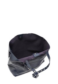 Tote bag nahkasta tummansinisessä värissä, jossa on pehmeä sisustus, napitus ja vetoketjullinen tasku. Ominaisuuksiin kuuluu jämäkkä muoto ja rei'itetyt yksityiskohdat varressa.