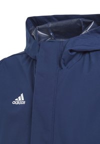 Veste à capuche navy avec une texture lisse, dotée d'un col montant et d'un logo Adidas blanc sur le côté gauche. Design simple et pratique.