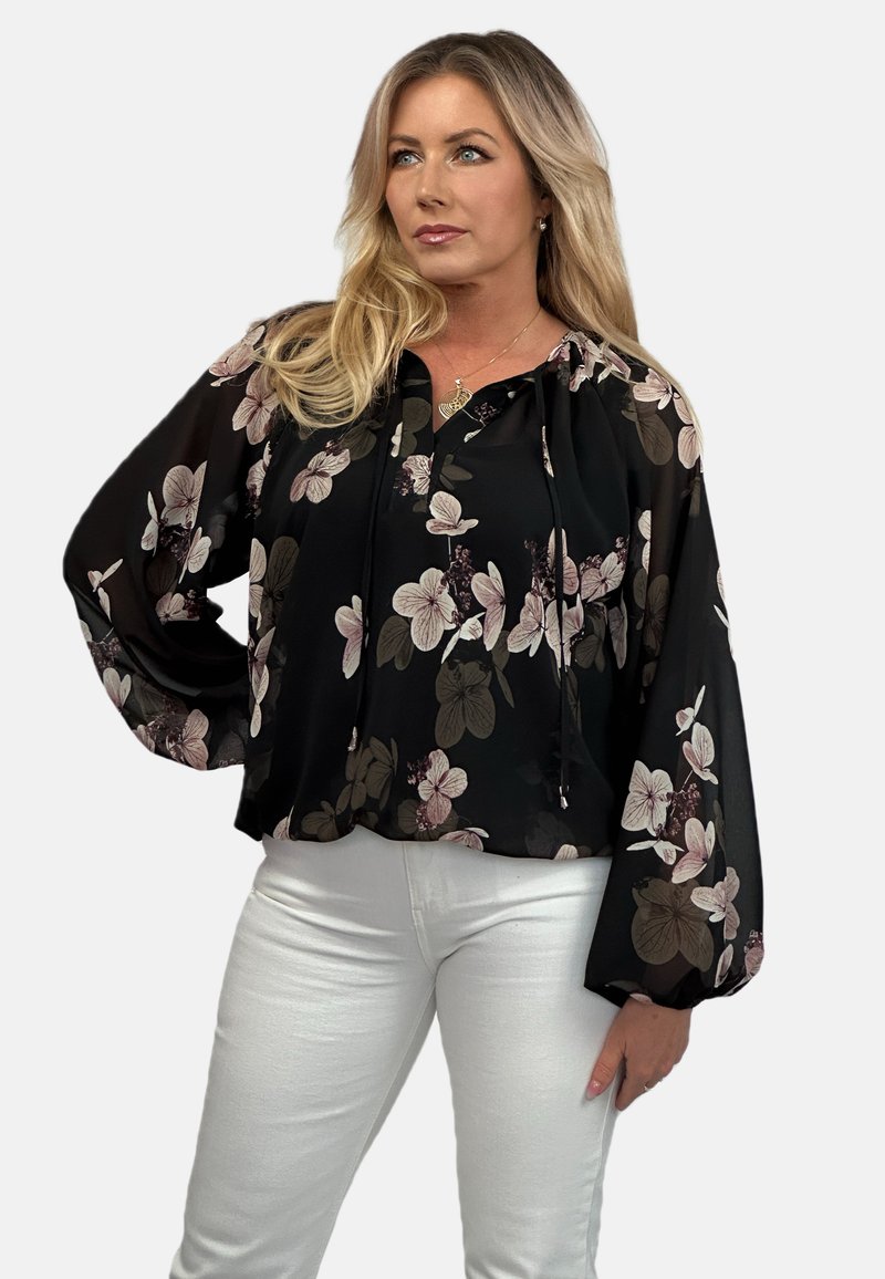 Czarna bluzka w kwiaty z balonowymi rękawami, zdobiona różowymi i bordowymi wzorami kwiatowymi. Lekki, zwiewny materiał z dekoltem ze sznurkiem.